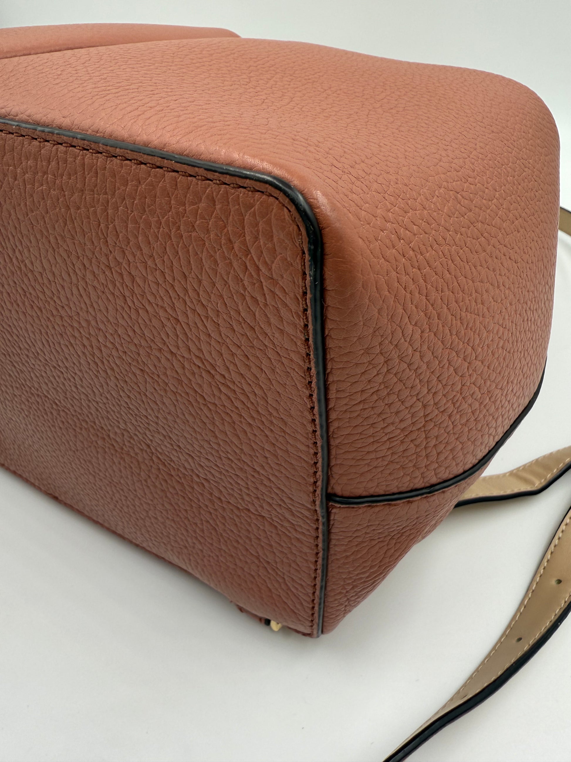 Michael Kors Peach Bedford large leather convertible backpack, close-up of textured base and side.