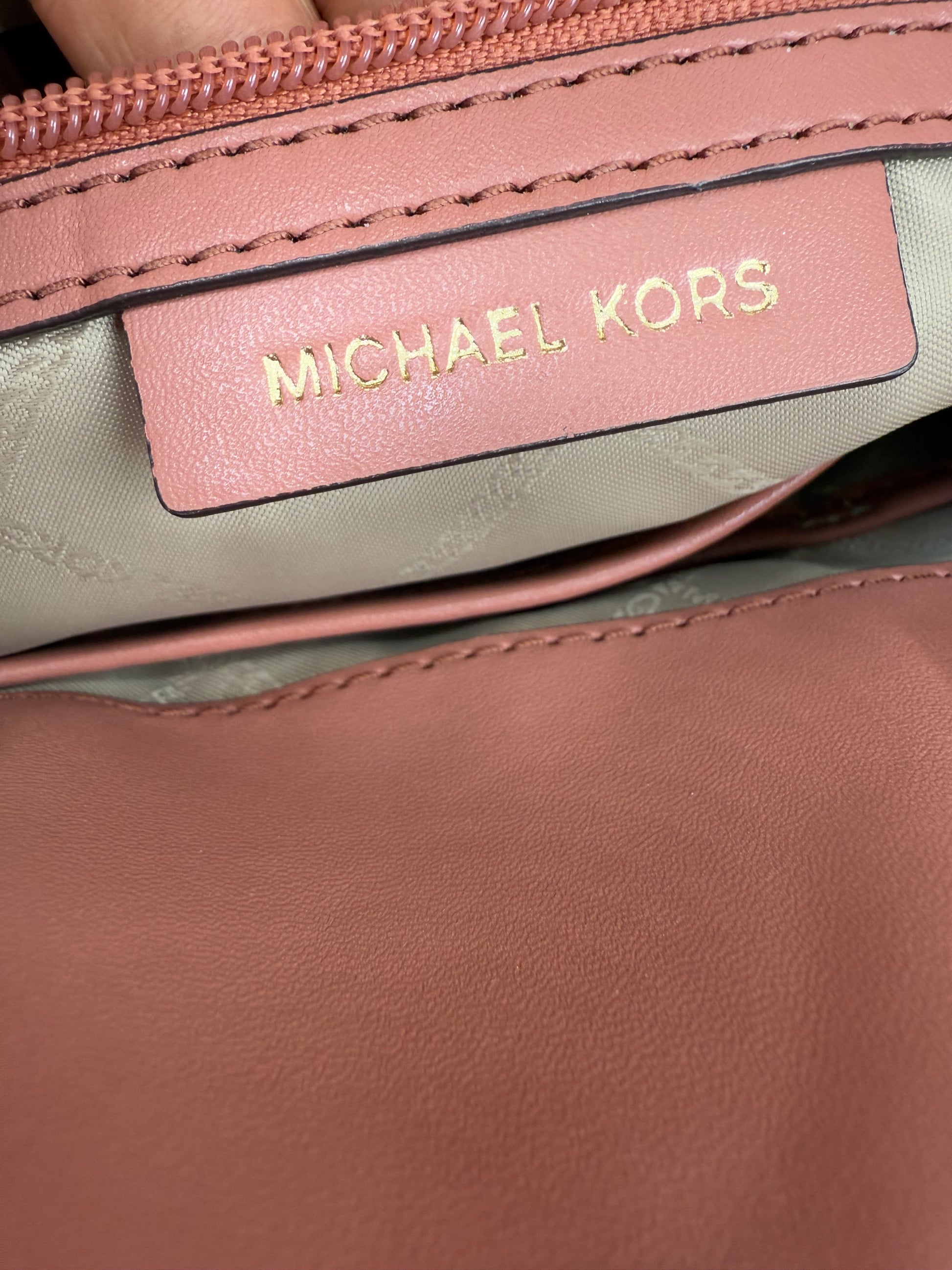 Close-up of Michael Kors Peach Bedford large leather convertible backpack interior with gold logo.