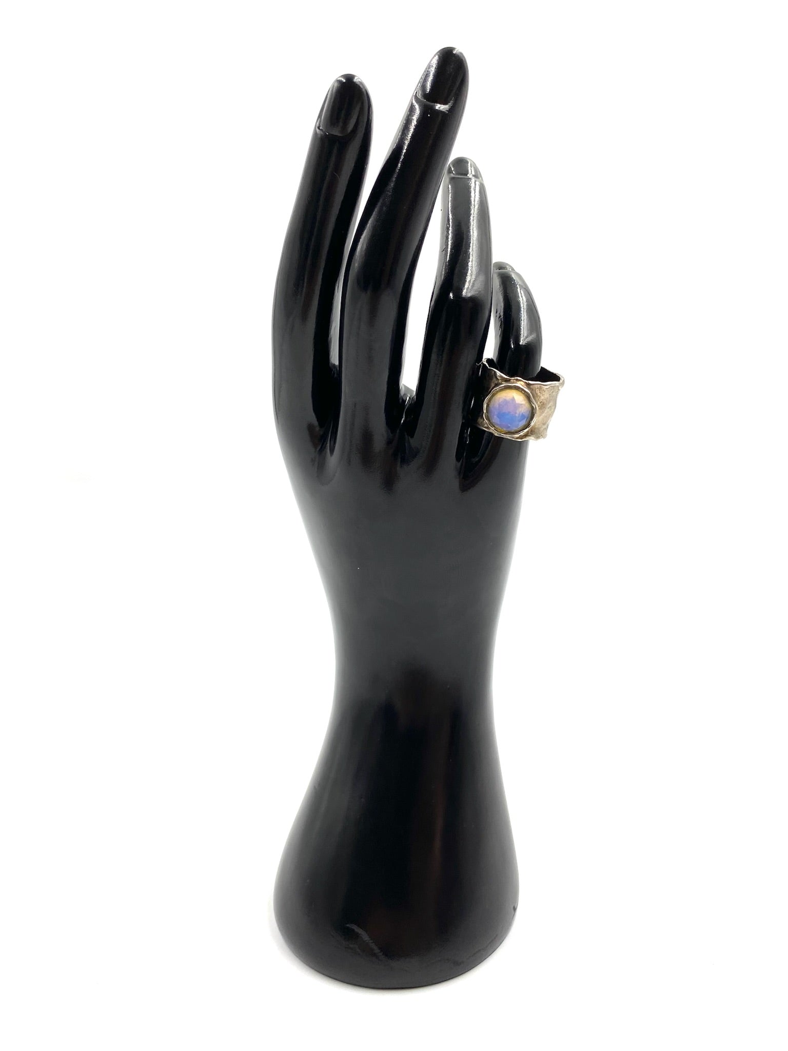 Chunky sterling silver ring with an iridescent moonstone, displayed on a black hand model. Size 6.75.