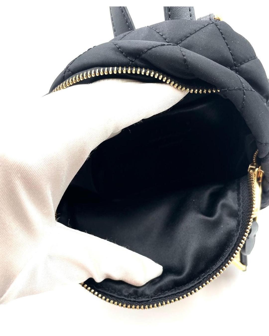 Interior of a black quilted nylon Moschino mini backpack with gold-tone zipper and smooth fabric lining.