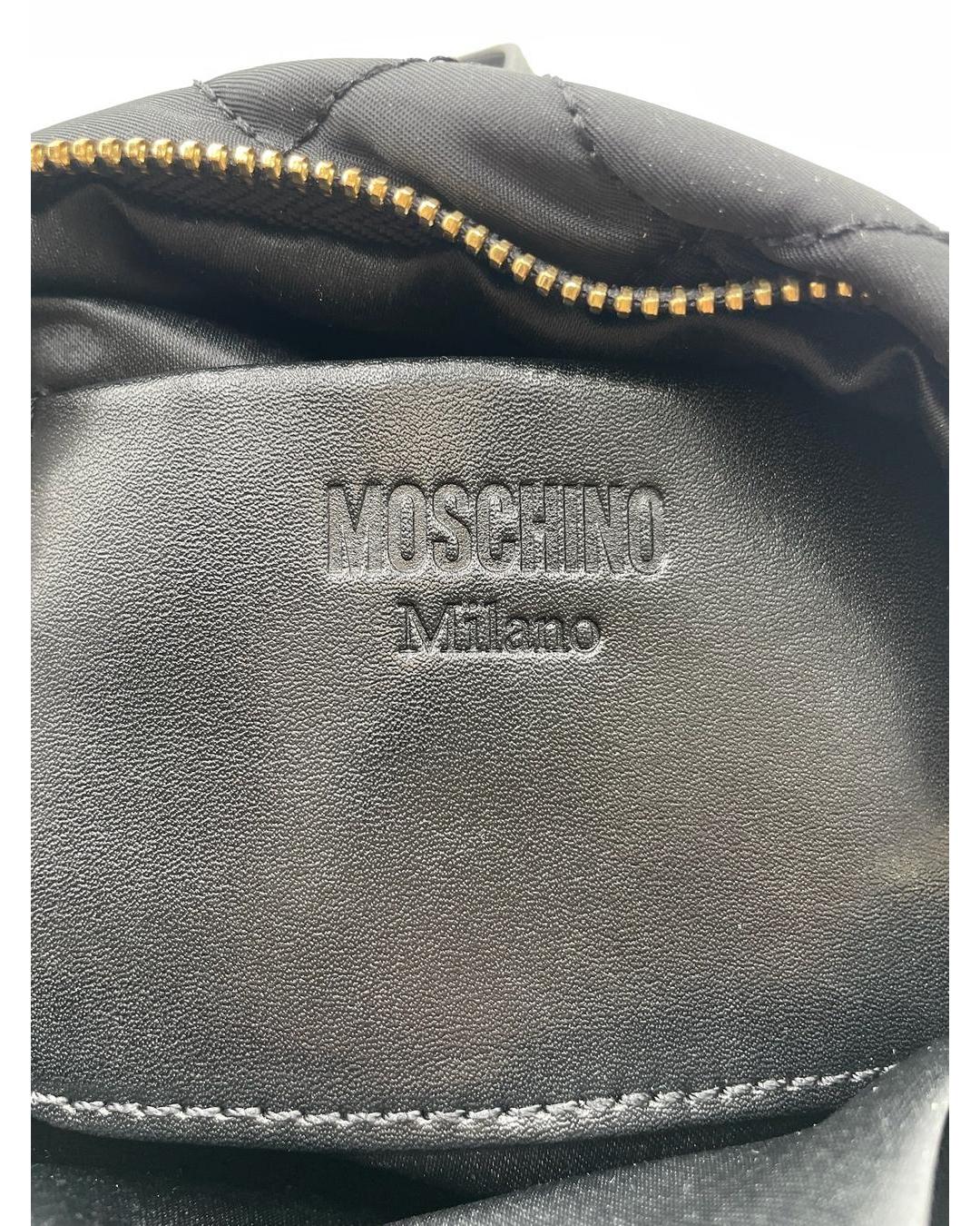 Black Moschino Milano embossed leather interior patch inside a quilted nylon mini backpack with gold zipper.