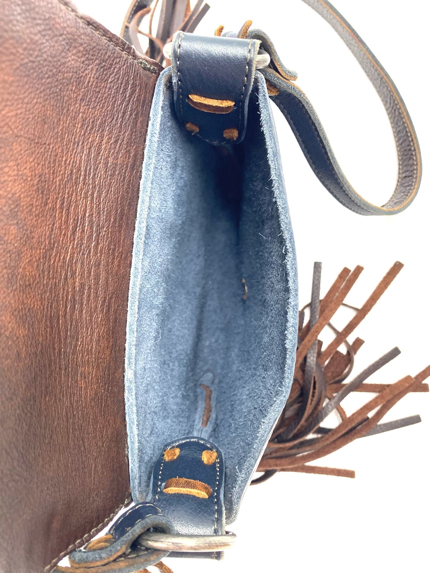 Navy fringe leather crossbody bag with brown leather body, silver studs, and tassel details.