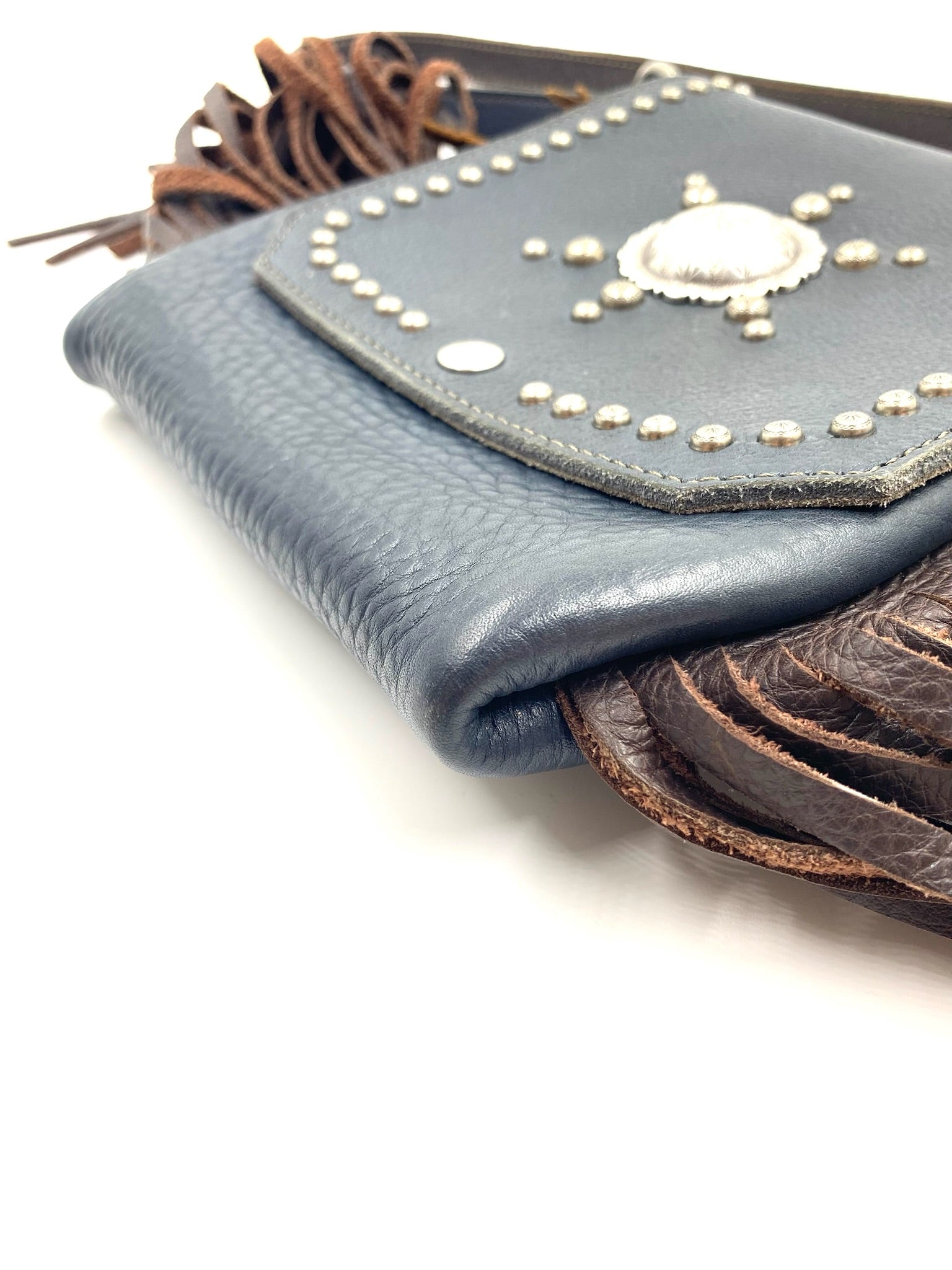 Navy fringe leather crossbody bag with silver studs and concho detail.