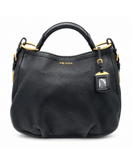 Prada black pebbled leather Vitello Daino hobo bag with gold hardware and a top handle.