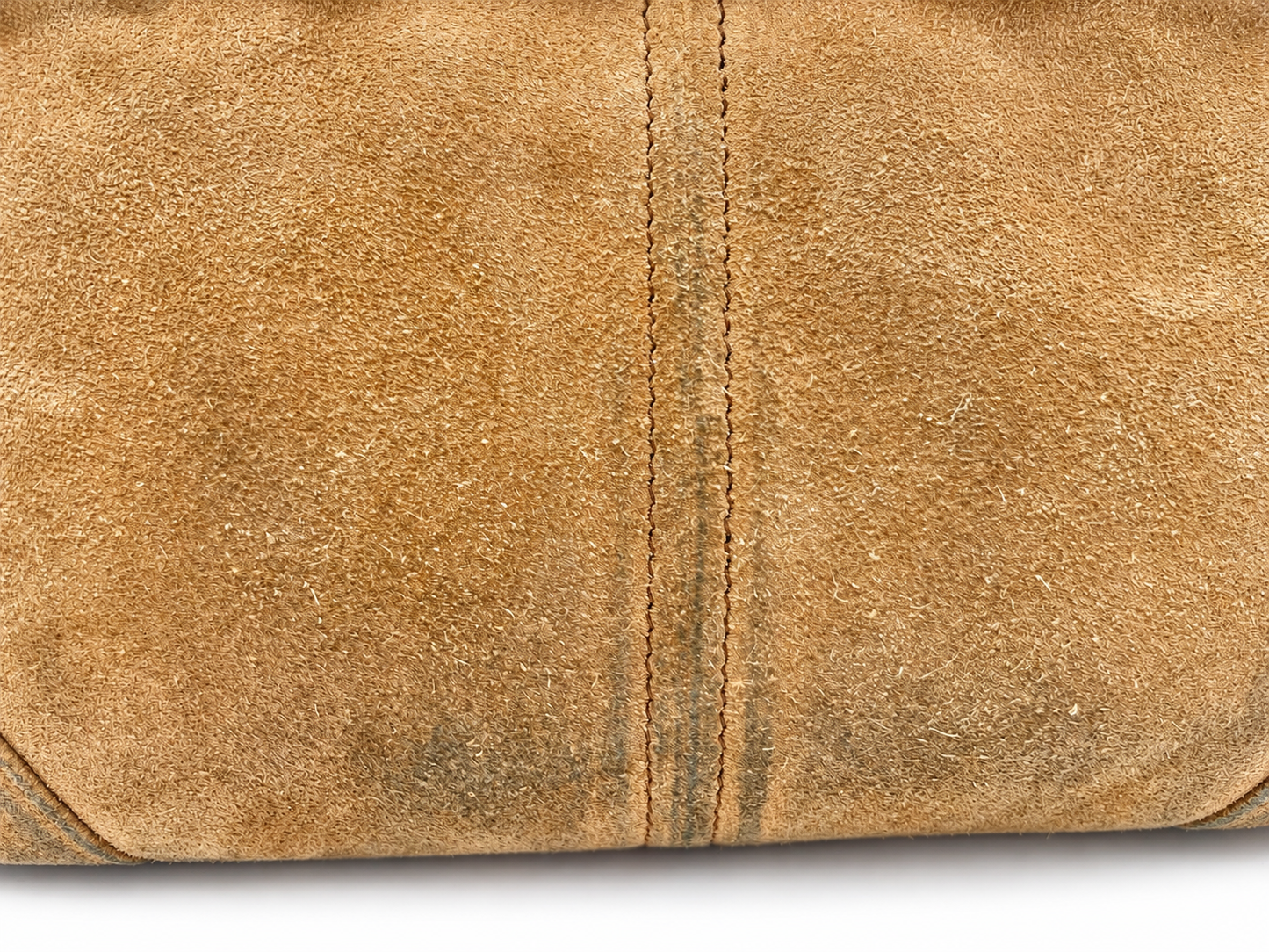 Close-up of cinnamon brown suede Prada Bonnie bag showing texture and visible color transfer along the center seam.