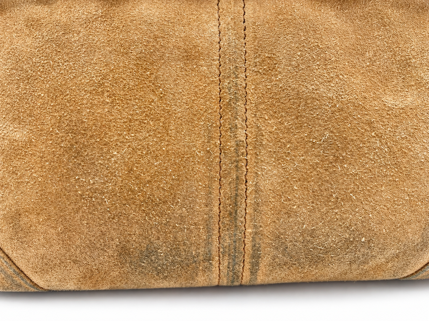 Close-up of cinnamon brown suede Prada Bonnie bag showing texture and visible color transfer along the center seam.