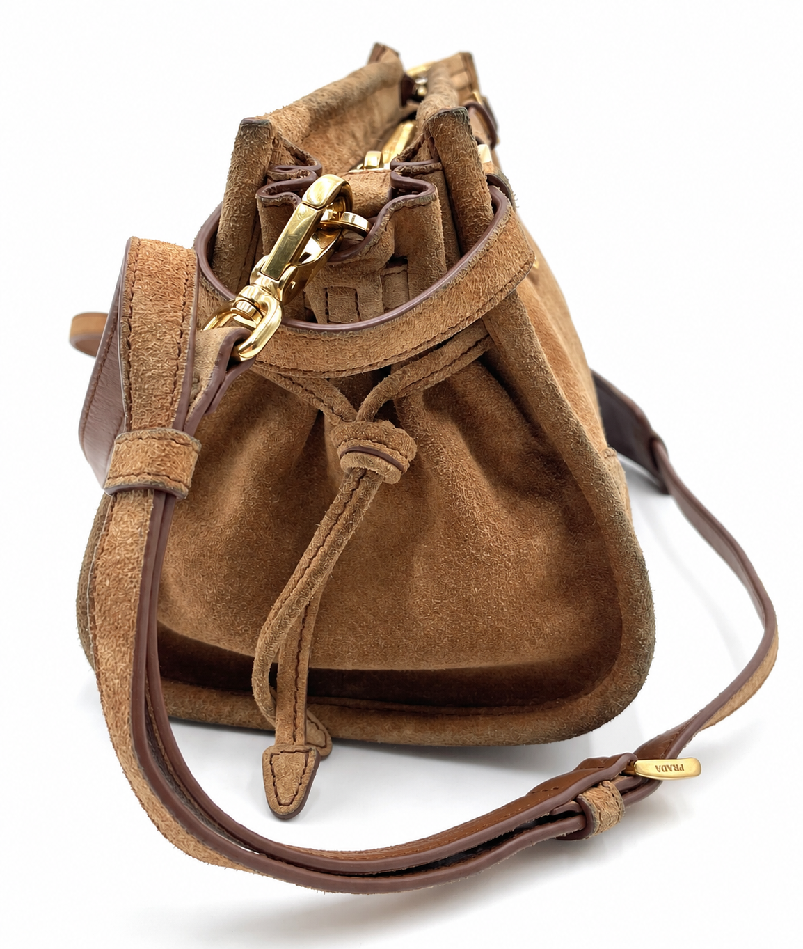 Prada Bonnie small cinnamon brown suede shoulder bag with gold hardware, drawstring details, and adjustable strap.
