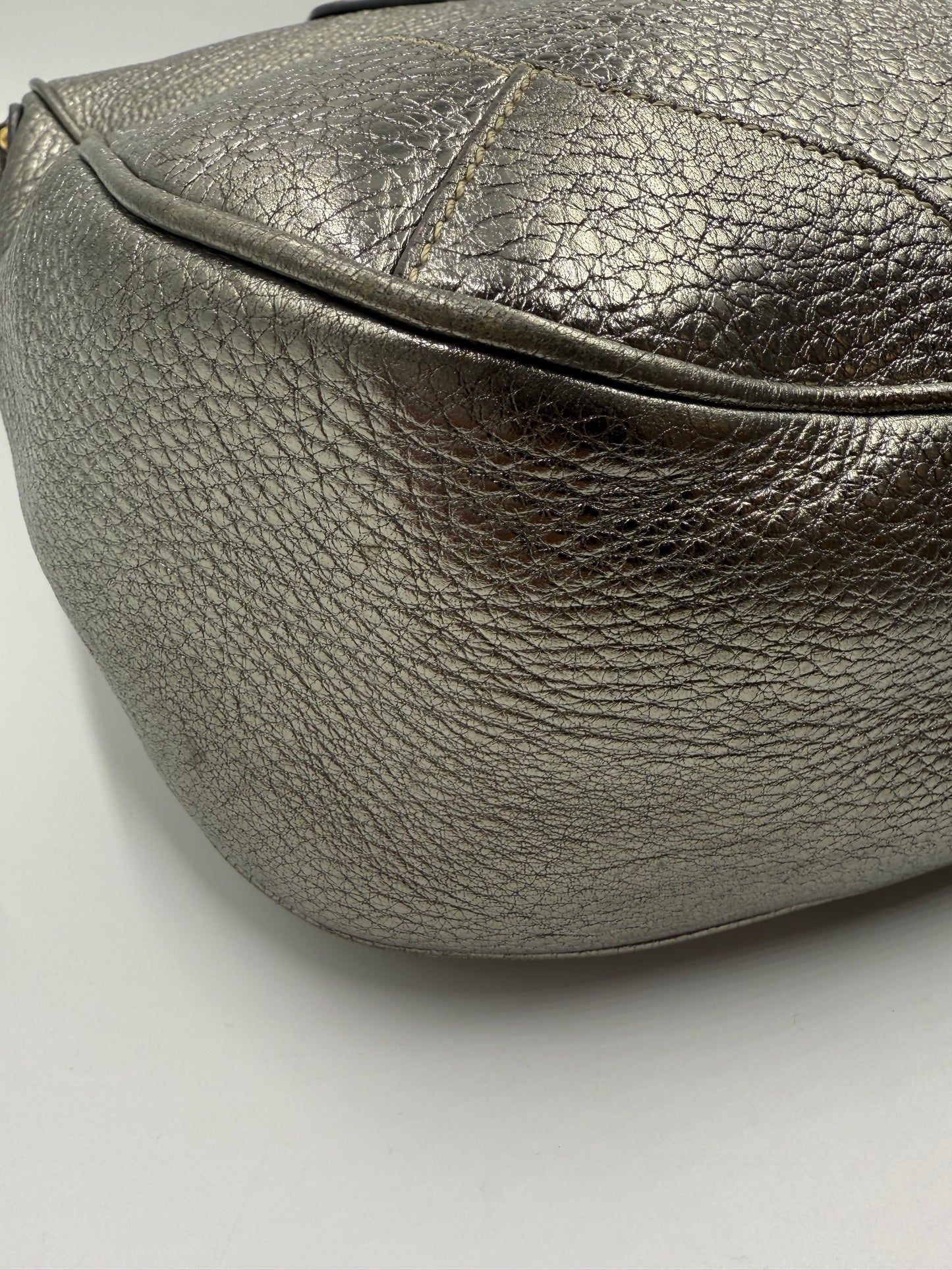 Prada Silver Metallic Vitello Daino Tote, close-up of textured leather, curved bottom.
