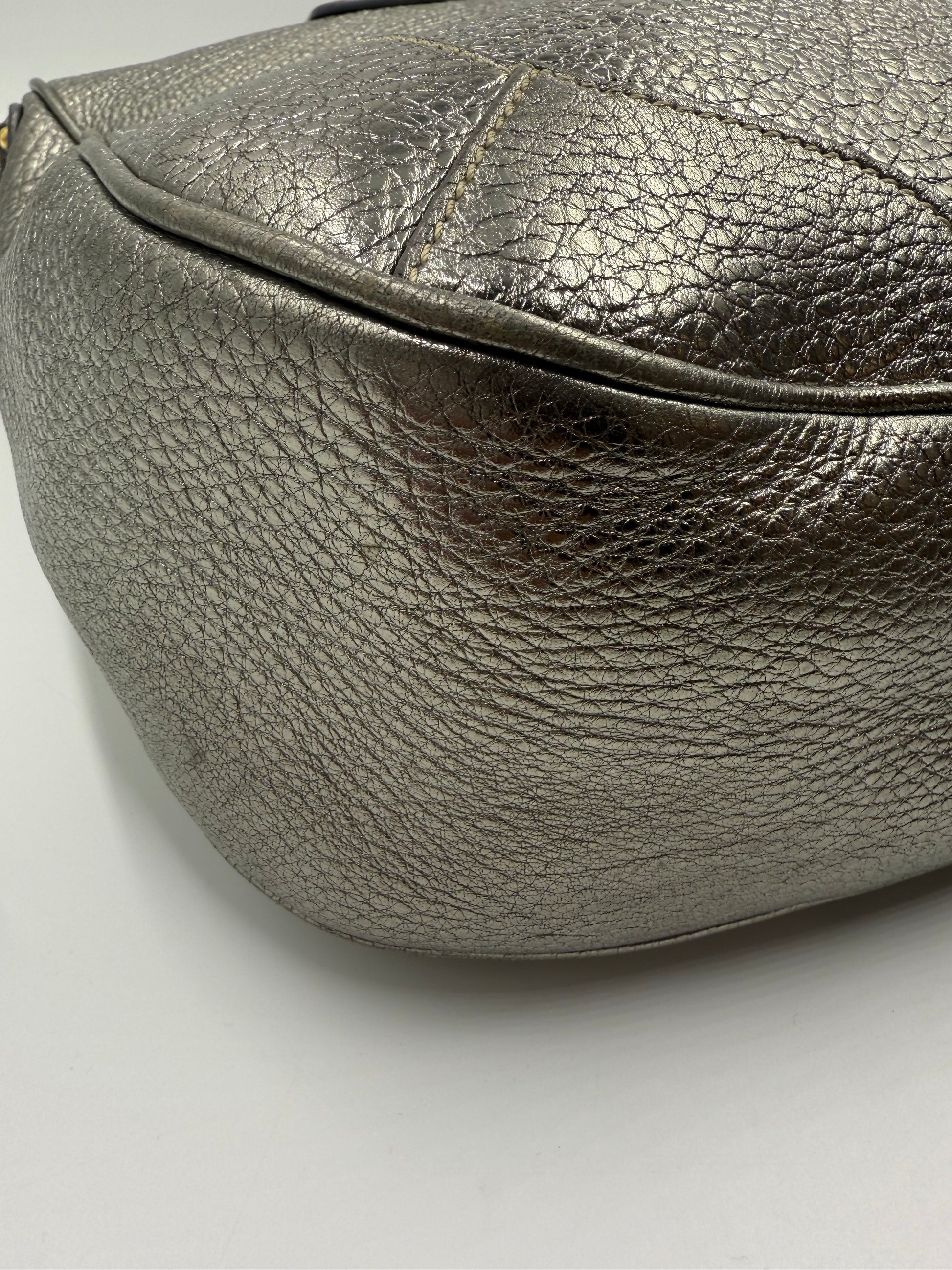 Prada Silver Metallic Vitello Daino Tote, close-up of textured leather, curved bottom.