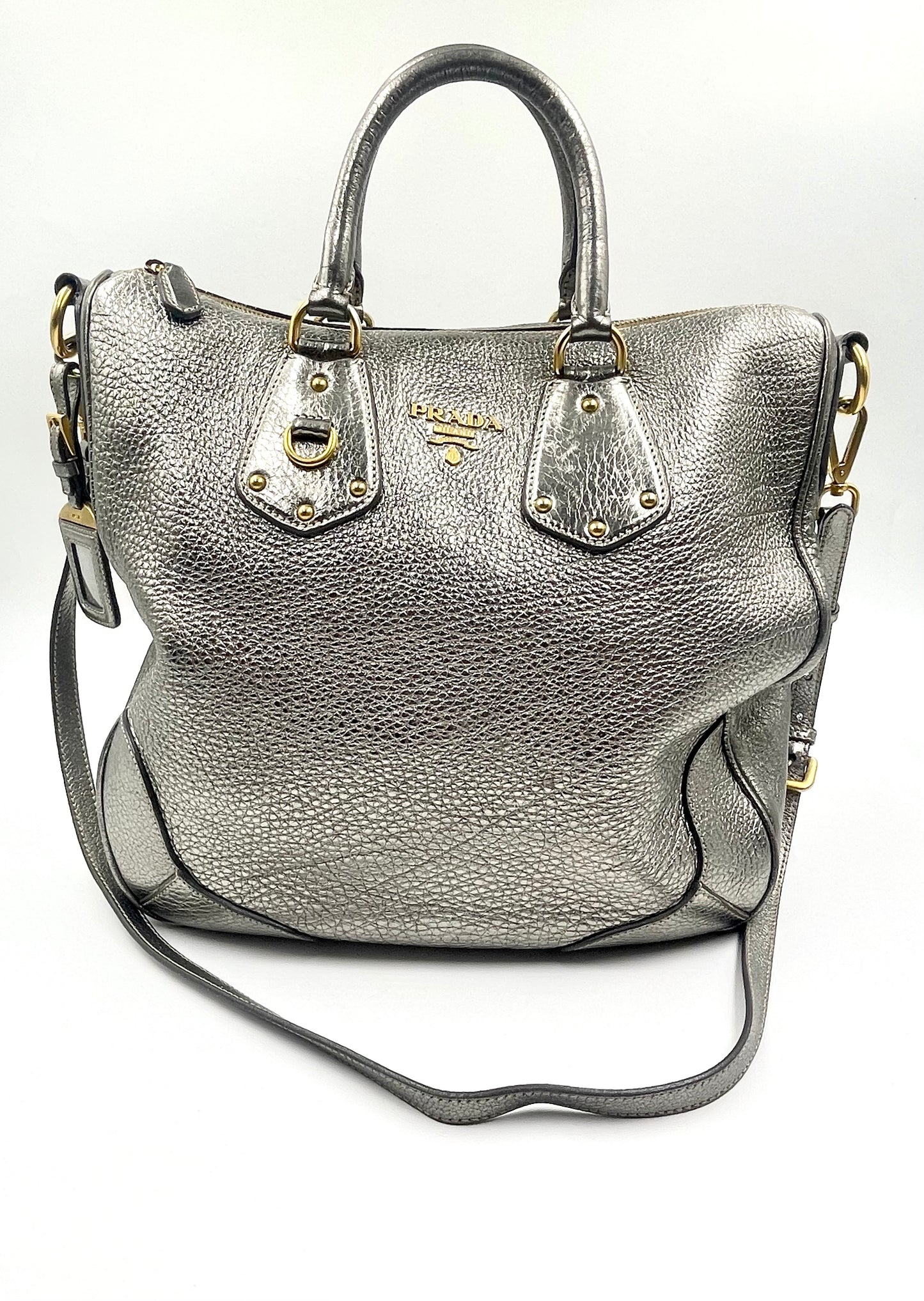 Prada Silver Metallic Vitello Daino Tote with rolled handles, gold hardware, and front logo.