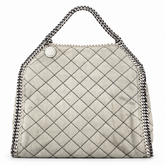 Stella McCartney grey quilted suede Falabella tote with silver chain trim and logo charm on a white background.