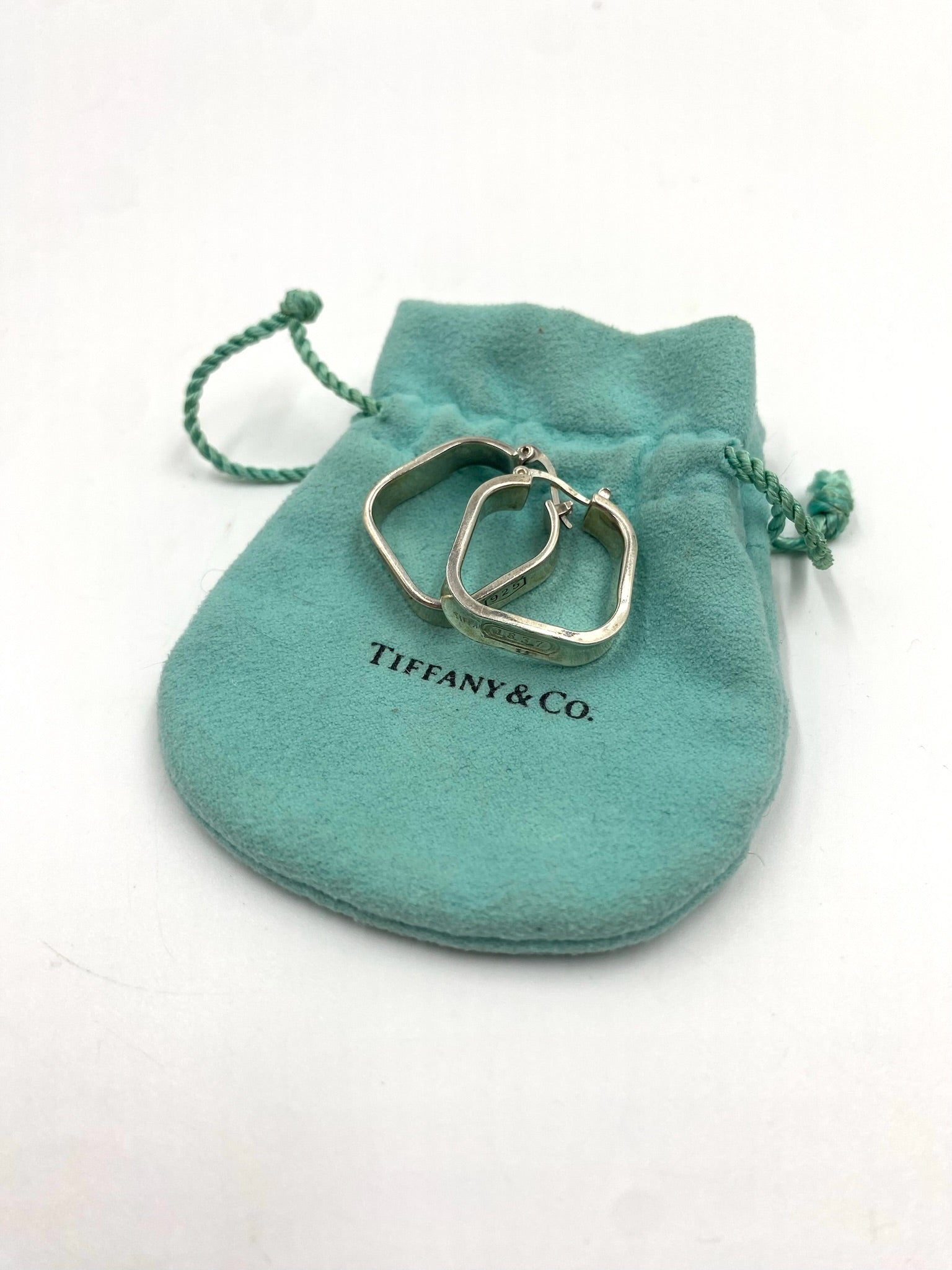 Tiffany & Co. 1837 sterling silver square hoop earrings on a Tiffany blue pouch.