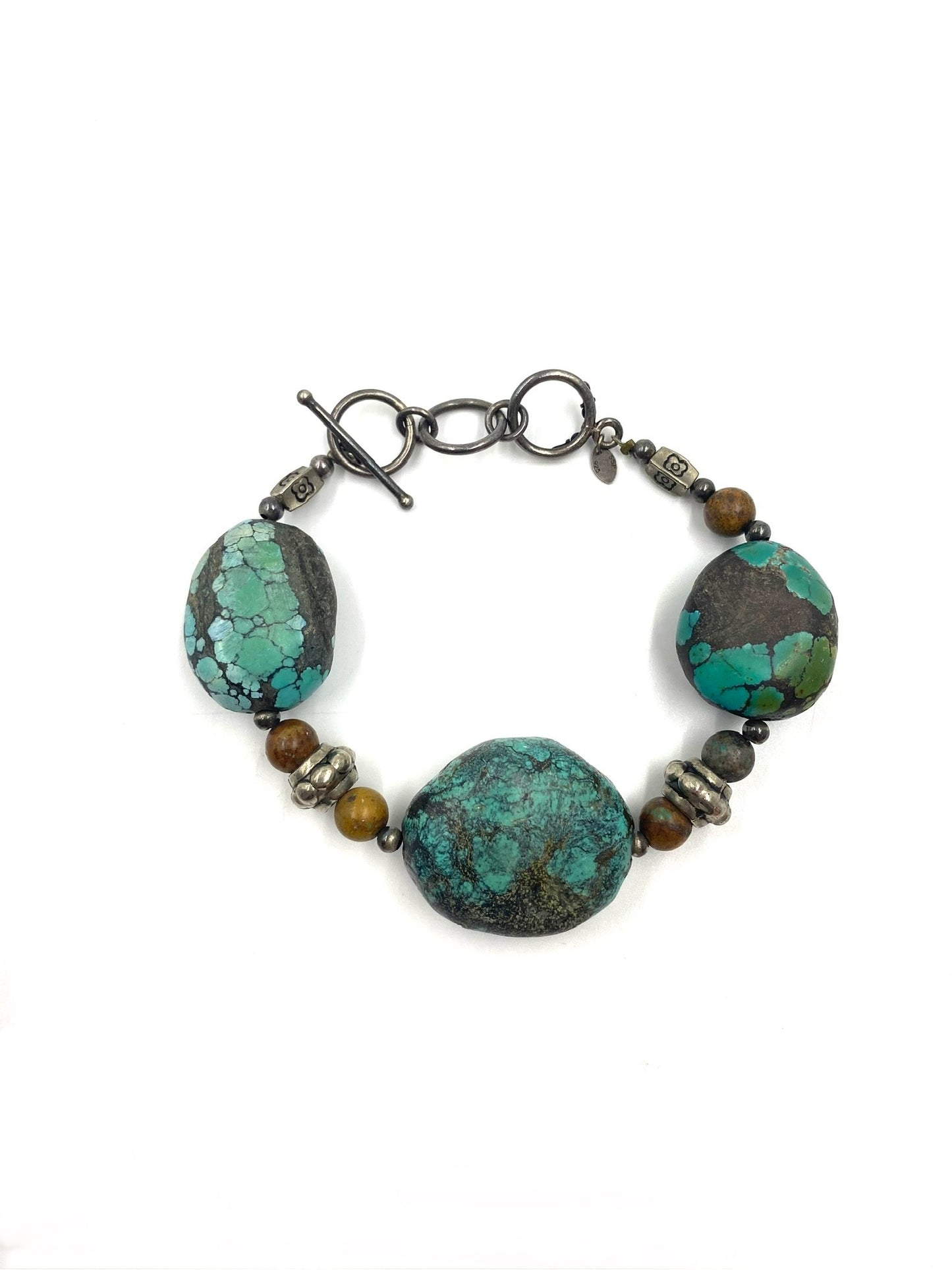 Turquoise stone bracelet with sterling silver toggle clasp and brown accent beads.
