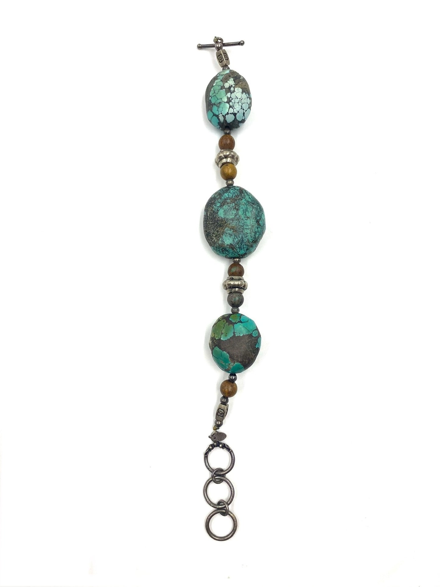 Turquoise stone bracelet with three large oval beads, smaller brown beads, and sterling silver toggle closure.