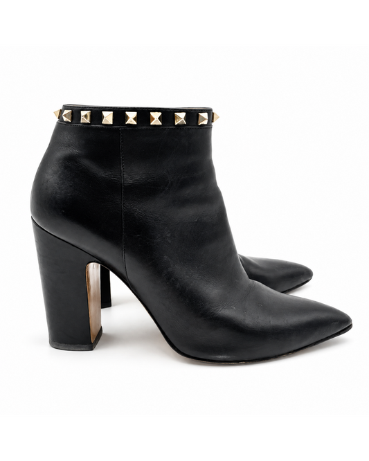 Valentino Garavani black leather pointed-toe ankle booties with gold stud trim and block heels.