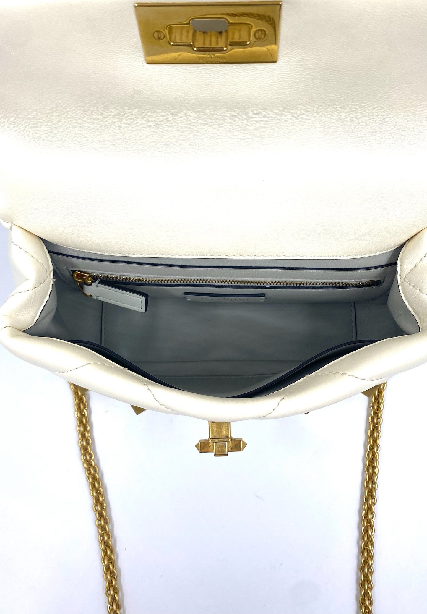 Valentino Garavani White Medium Roman Stud Bag, open, showing inside slip and zip pockets, gold hardware.