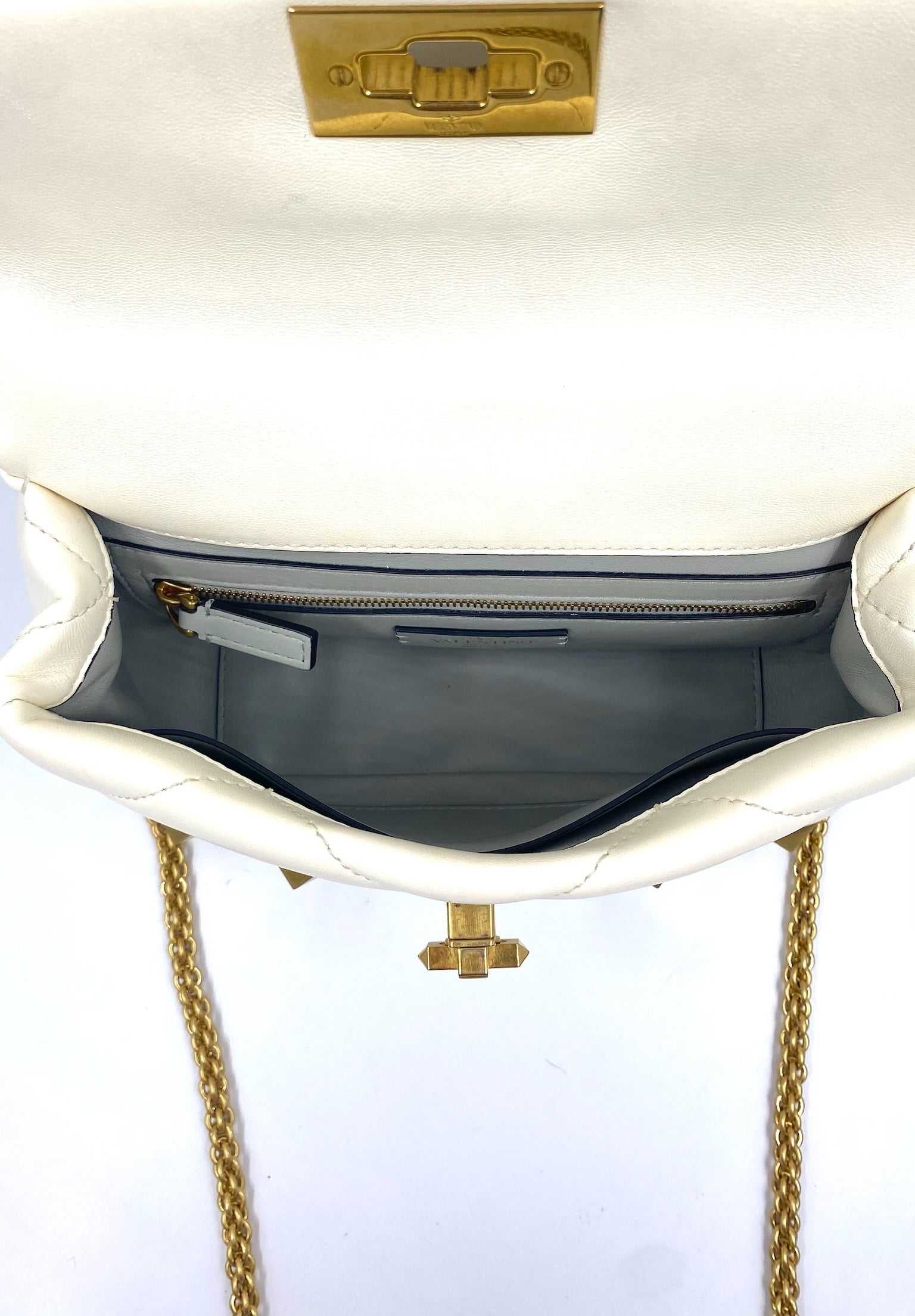 Valentino Garavani White Medium Roman Stud Bag, open, showing inside slip and zip pockets, gold hardware.