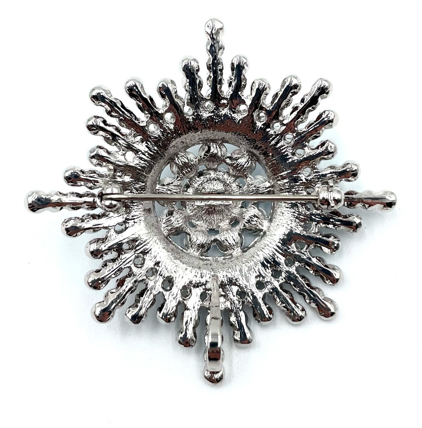 Back of a vintage silver-tone Butler sunburst brooch with a pin clasp.