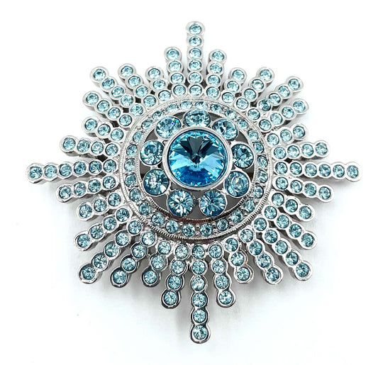 Vintage Butler blue crystal sunburst brooch with sparkling round stones and a large central blue gem.