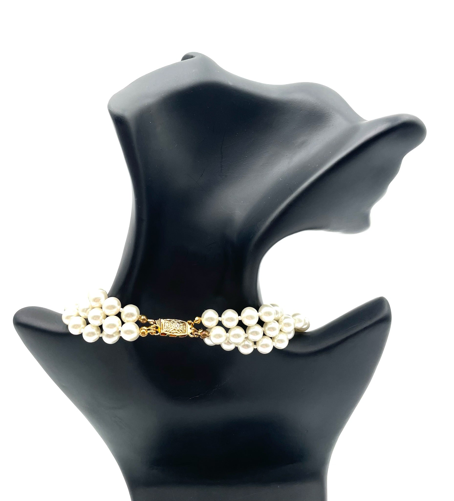 Vintage faux pearl choker necklace with two strands and a gold clasp, displayed on a black bust.