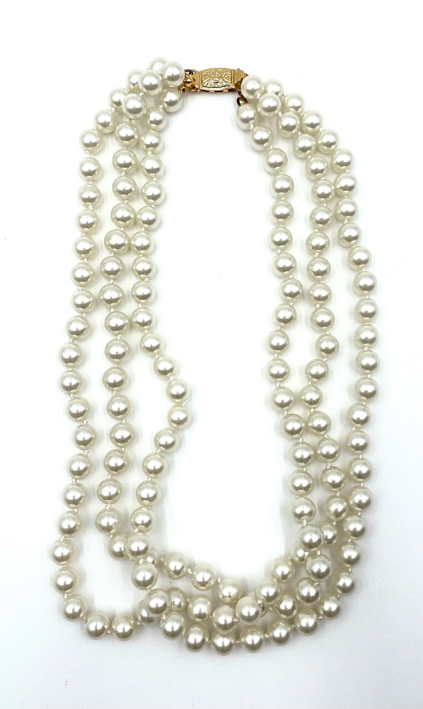 Vintage faux pearl choker necklace with three strands and a gold clasp.