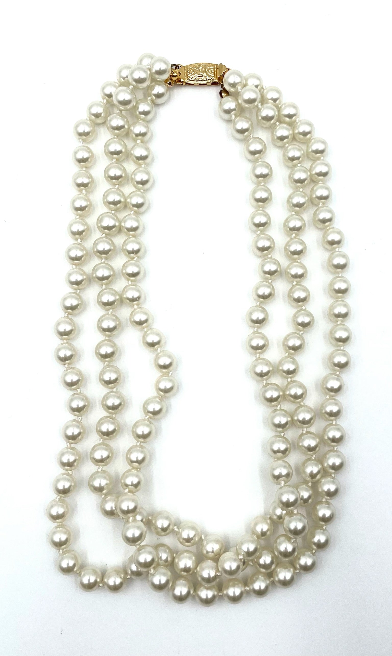 Vintage faux pearl choker necklace with three strands and a gold clasp.