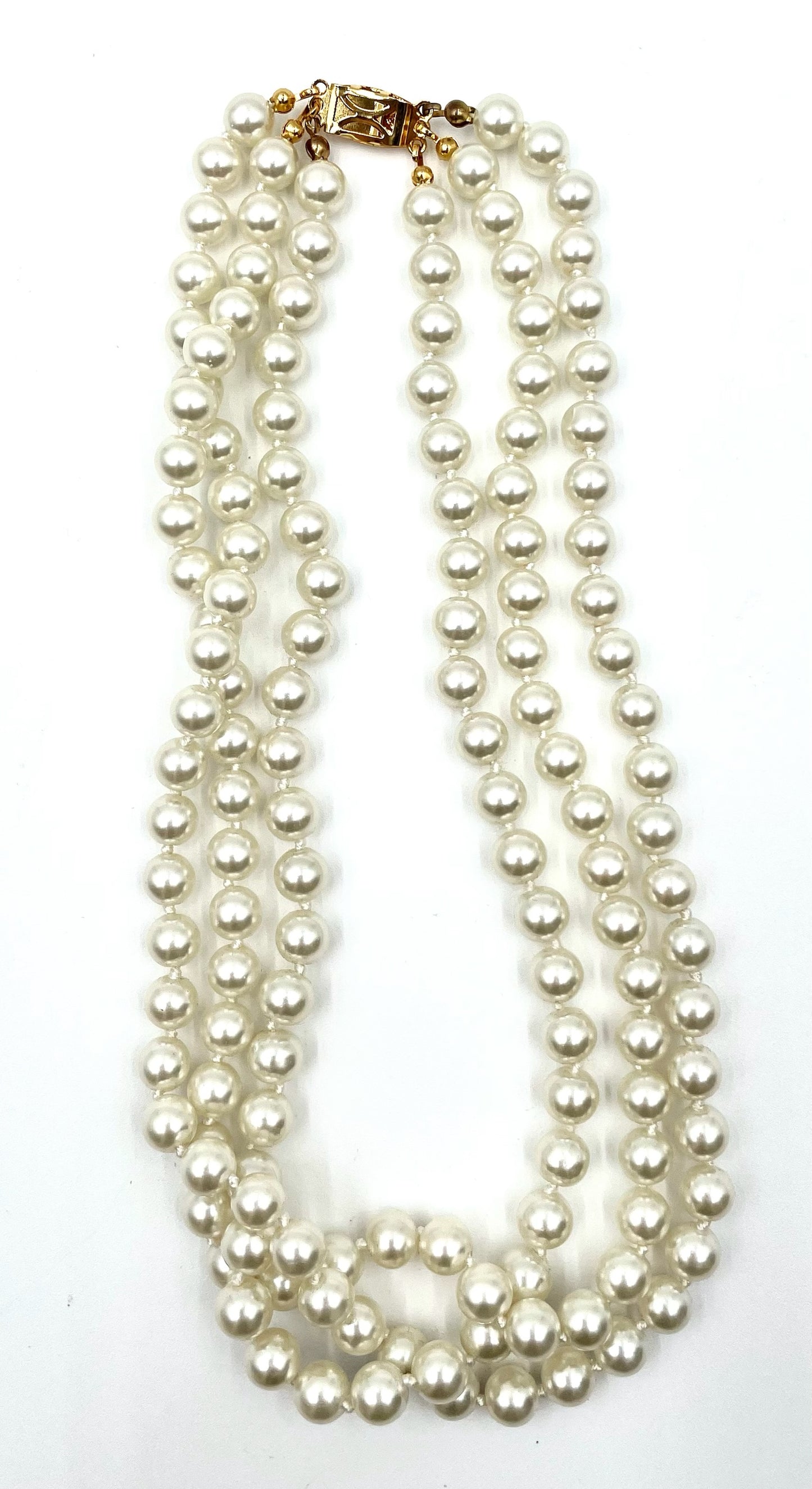 Vintage faux pearl choker necklace with three strands of white pearls and a gold clasp.