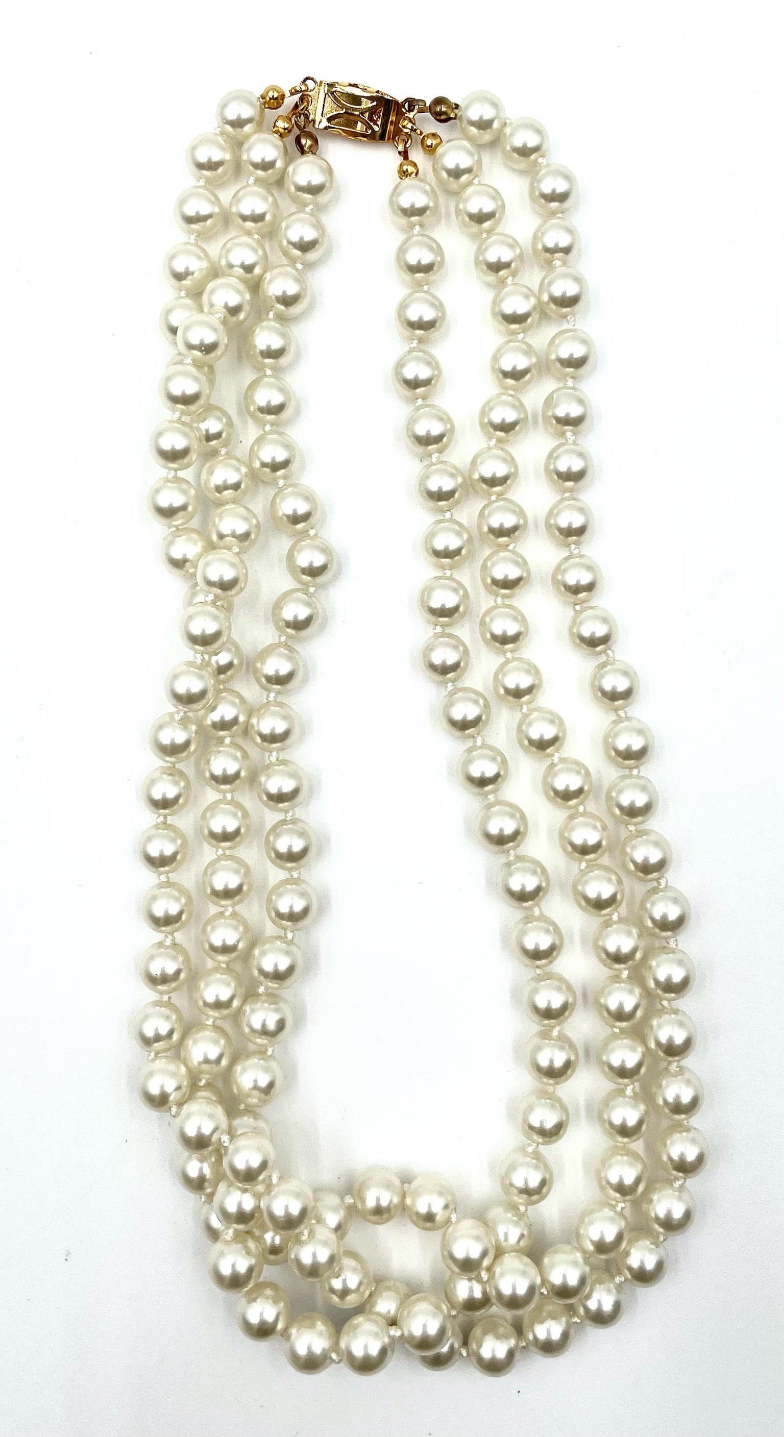Vintage faux pearl choker necklace with three strands of white pearls and a gold clasp.