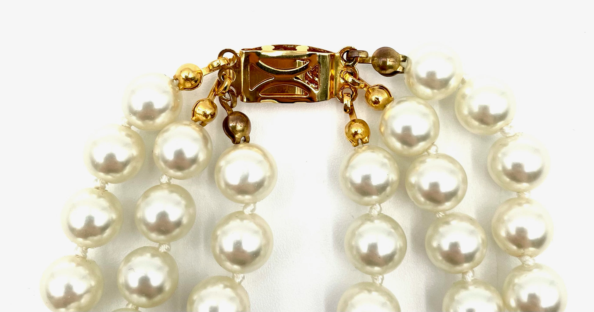 Vintage multi-strand faux pearl choker necklace with a gold clasp closure.