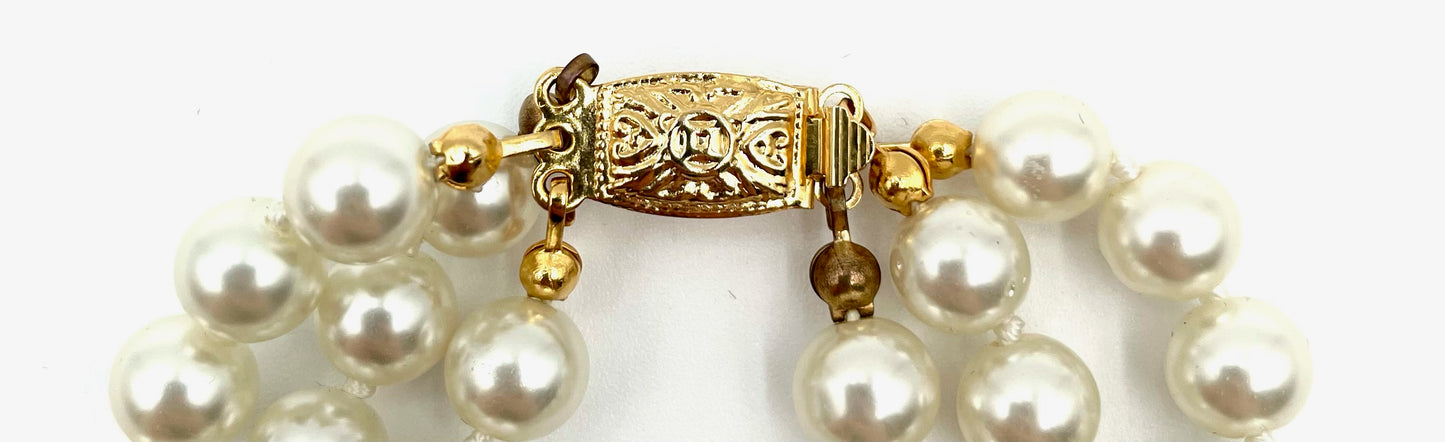 Vintage multi-strand faux pearl choker necklace with ornate gold clasp.