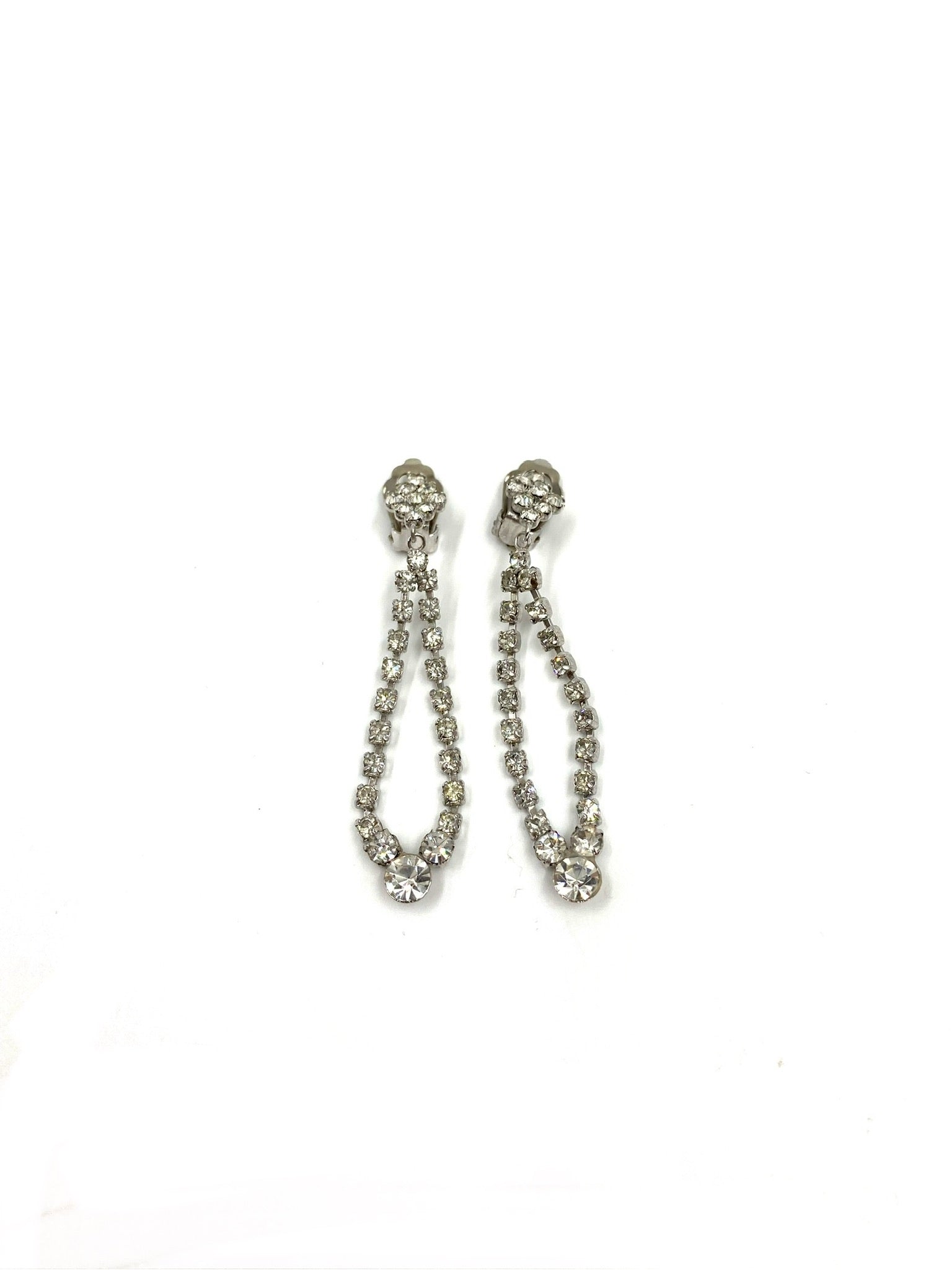 Vintage silver-tone rhinestone drop earrings, 2.5" long, featuring a sparkling looped design.