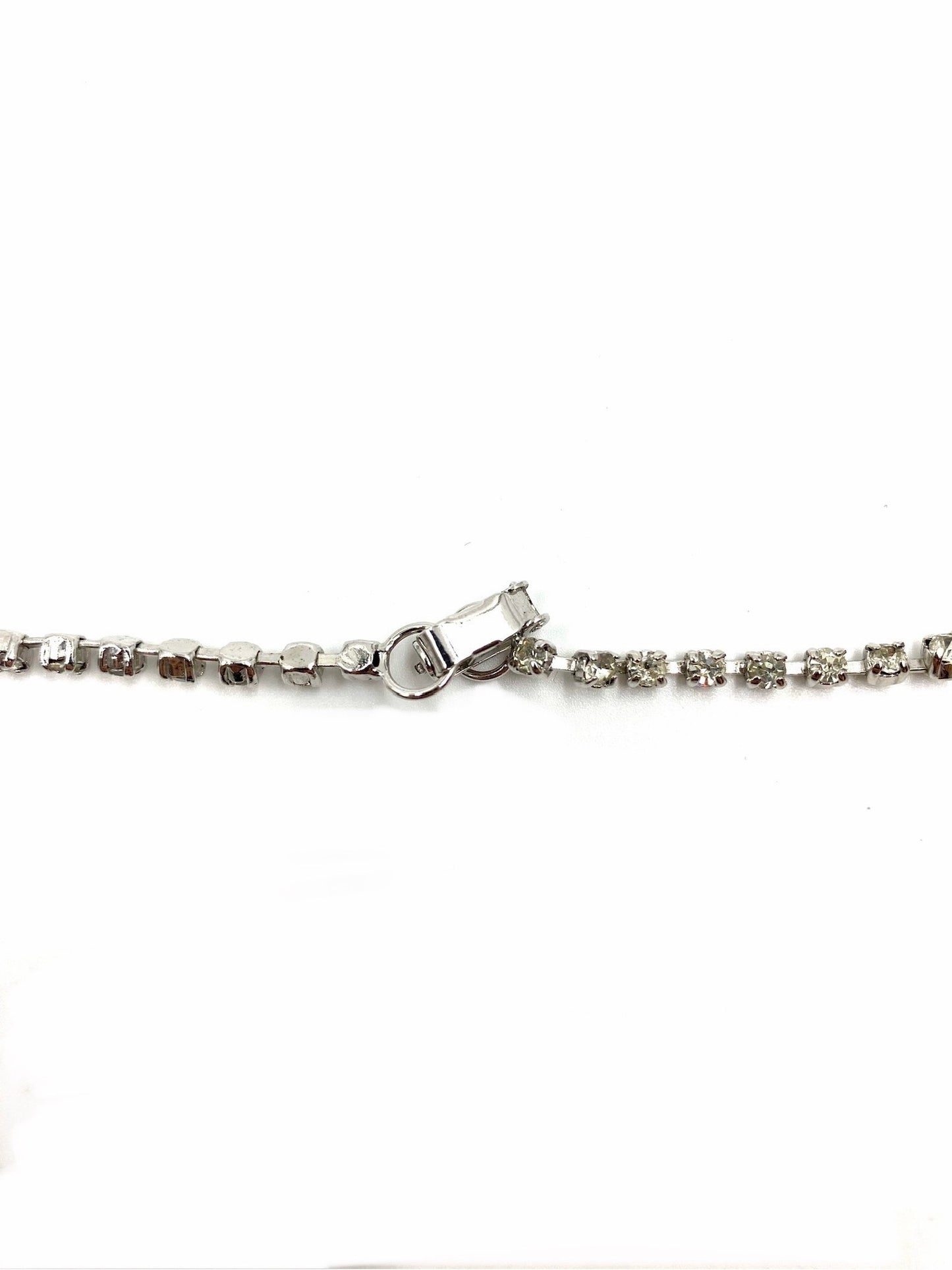 Close-up of a silver-tone vintage rhinestone necklace clasp and chain.
