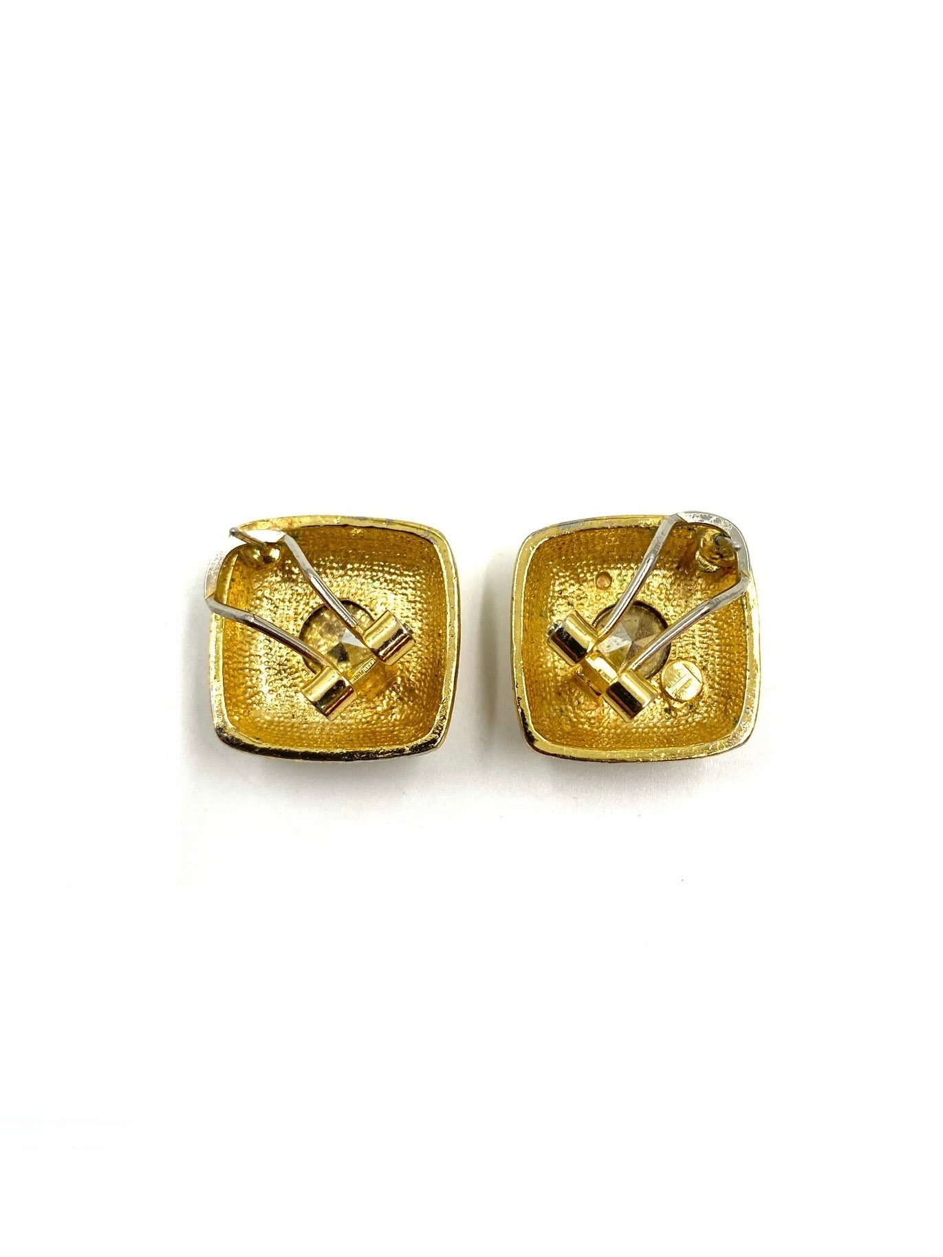 Back view of two vintage square gold-toned clip earrings with textured finish and metal clips.