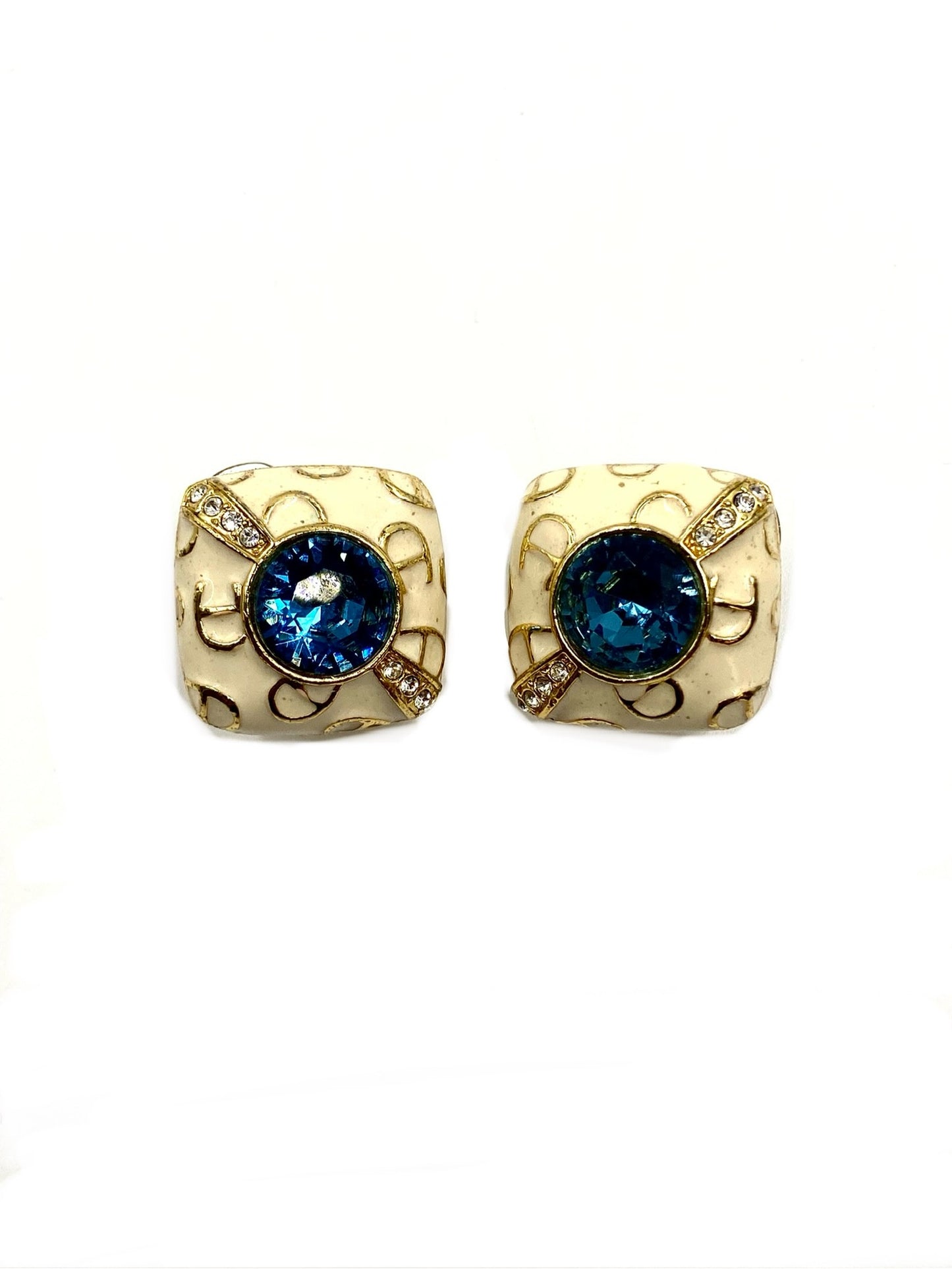Vintage white enamel clip earrings with large faux sapphire cabochons and surrounding faux diamonds.