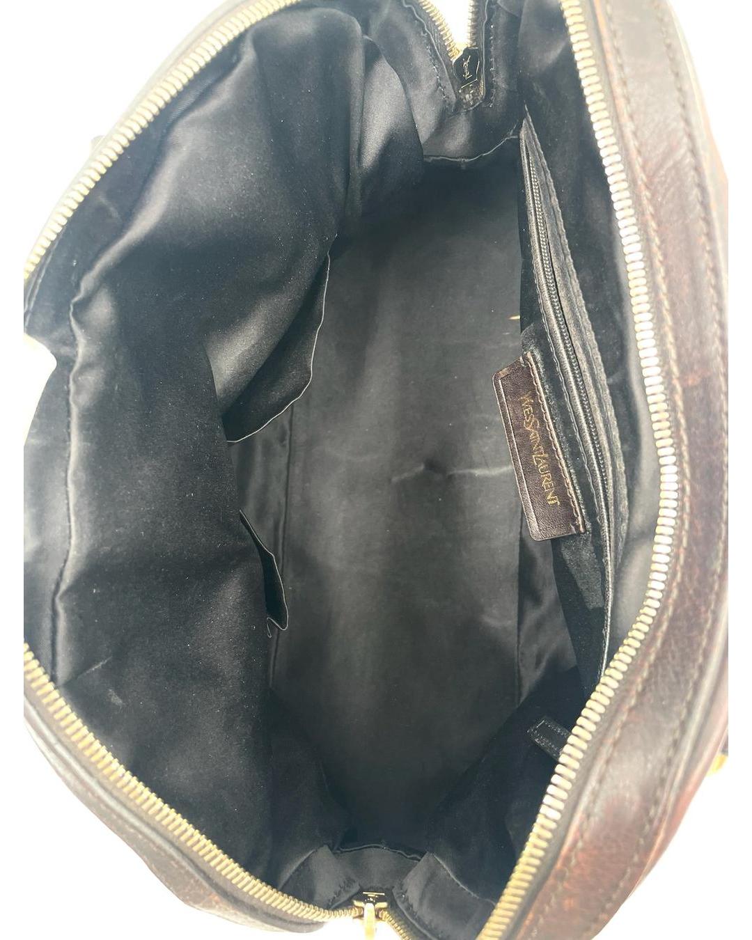 Interior view of a dark brown Yves Saint Laurent Muse bag featuring black fabric lining and a gold-tone zip closure.